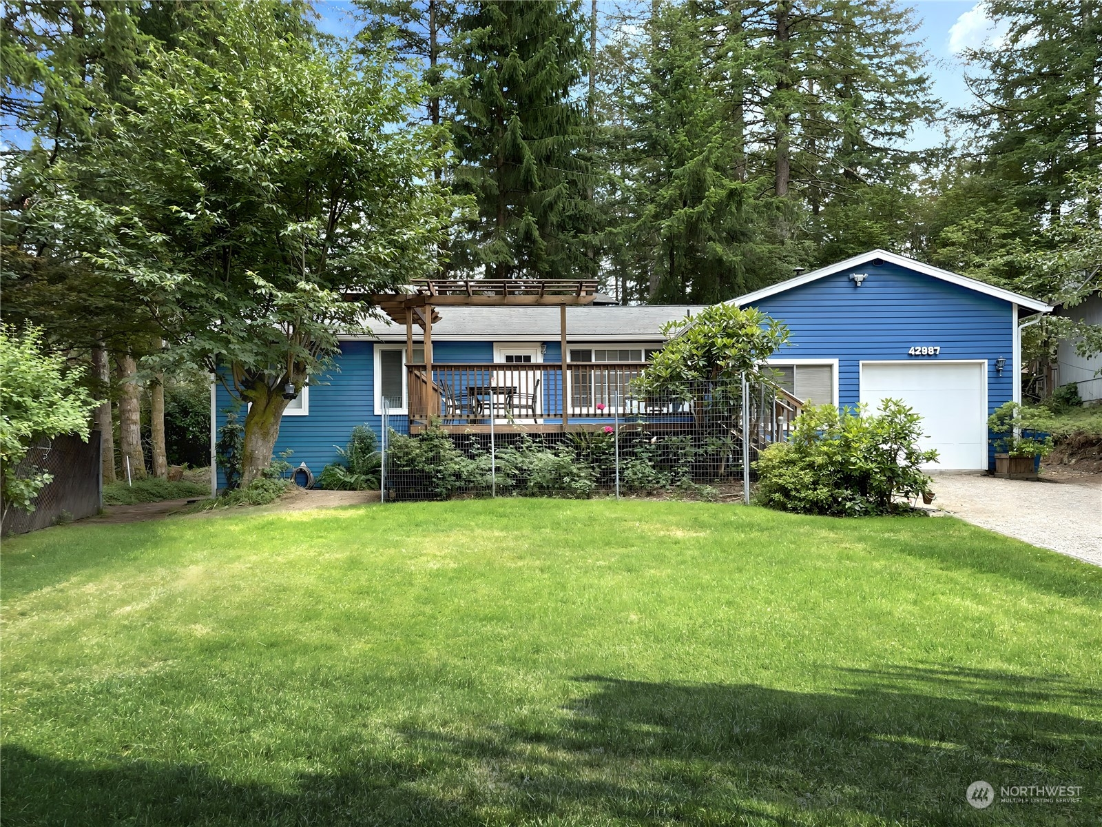 a front view of a house with a yard and trees