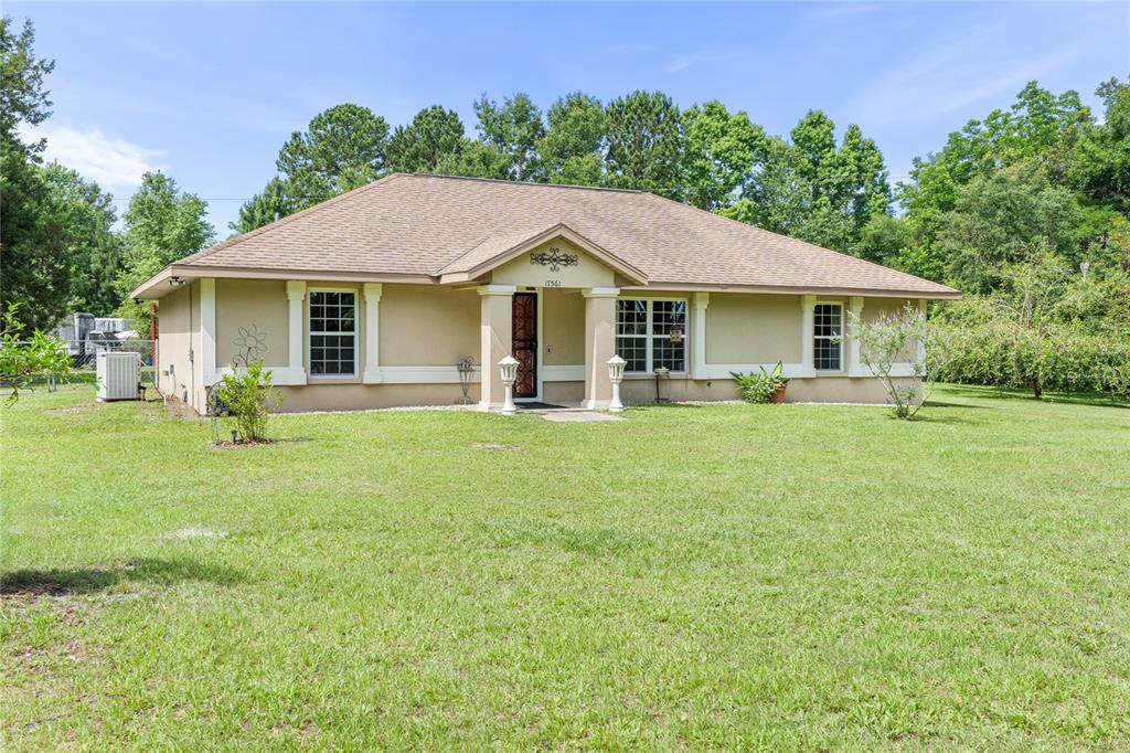 a front view of a house with a garden and trees