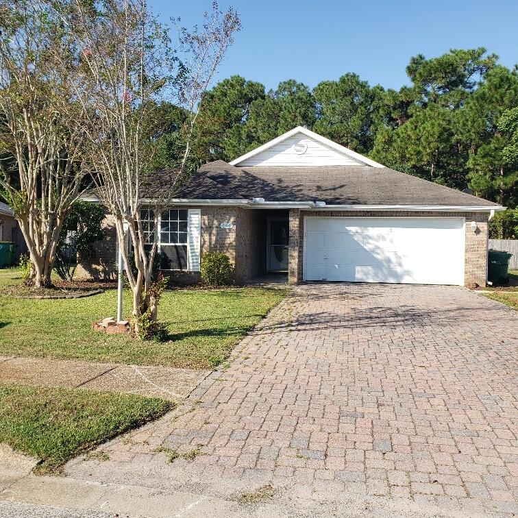 a front view of a house with a yard and trees