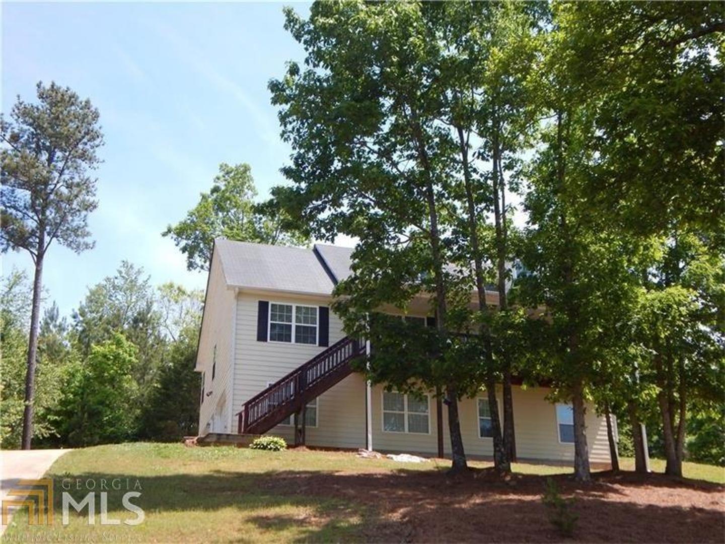 a view of a house with a tree next to a yard