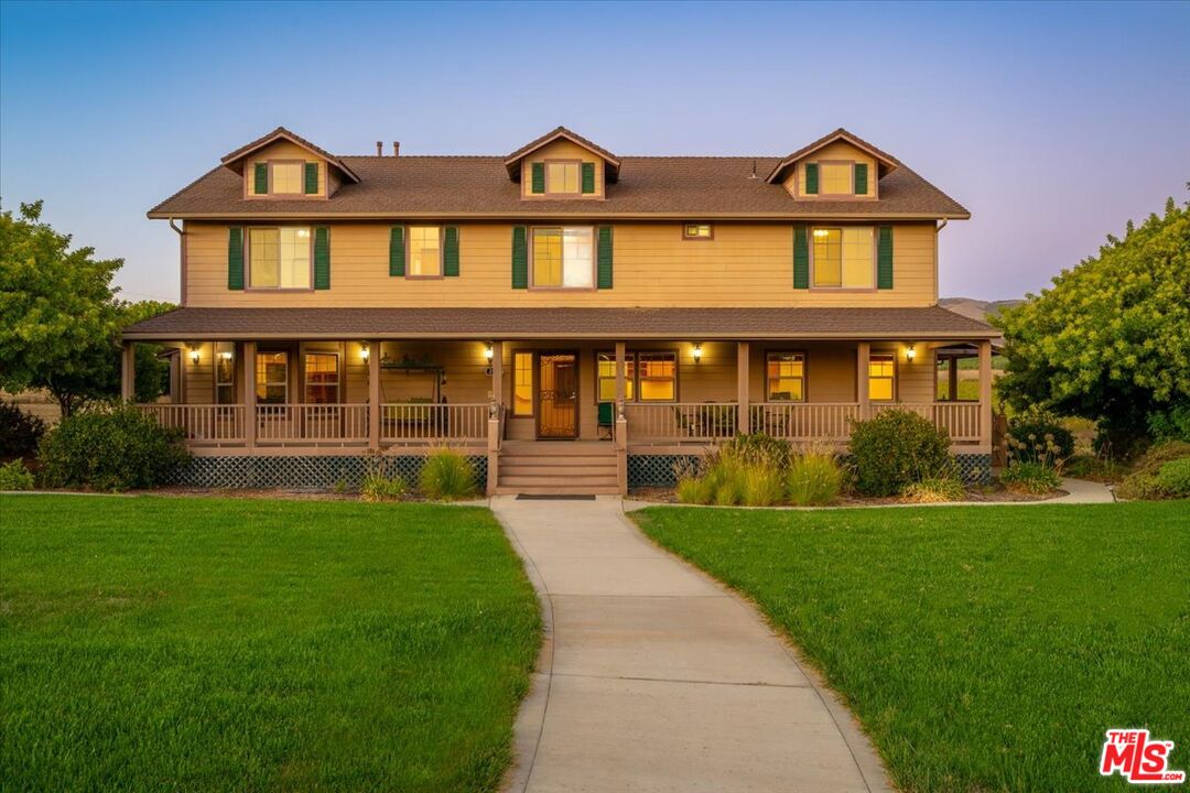 a front view of a house with yard and green space