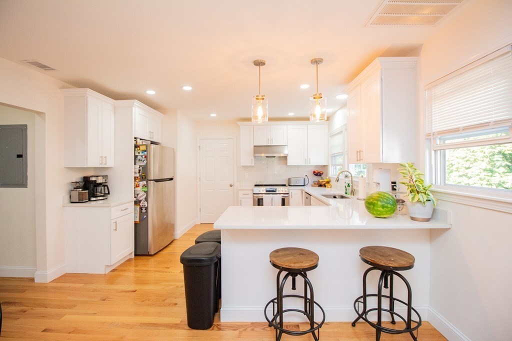 a kitchen with stainless steel appliances kitchen island granite countertop a refrigerator and a sink