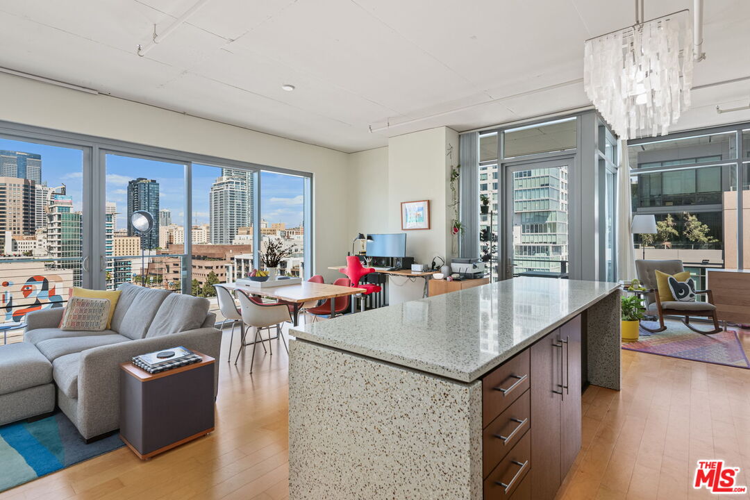 a view of kitchen island with stainless steel appliances granite countertop sink stove and wooden floor