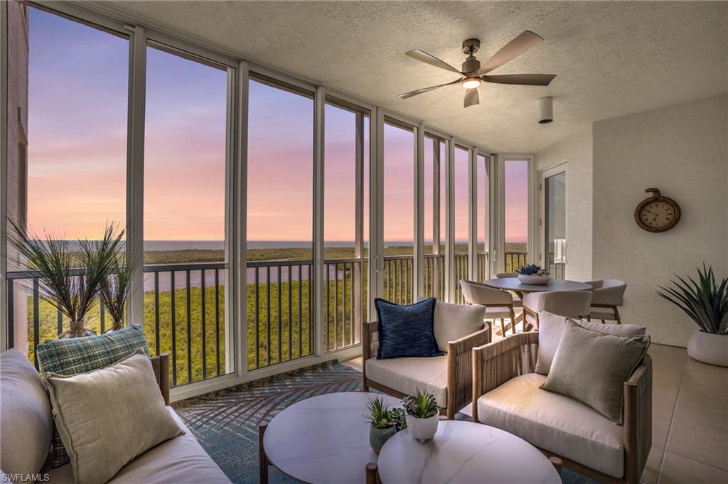 Sunroom featuring plenty of natural light, a water view, and ceiling fan