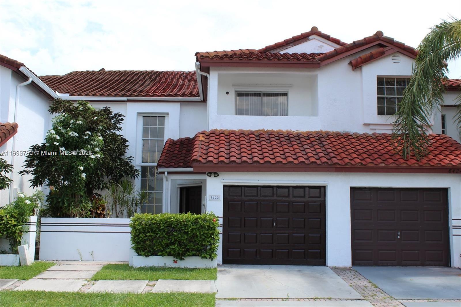 a front view of a house with a garden