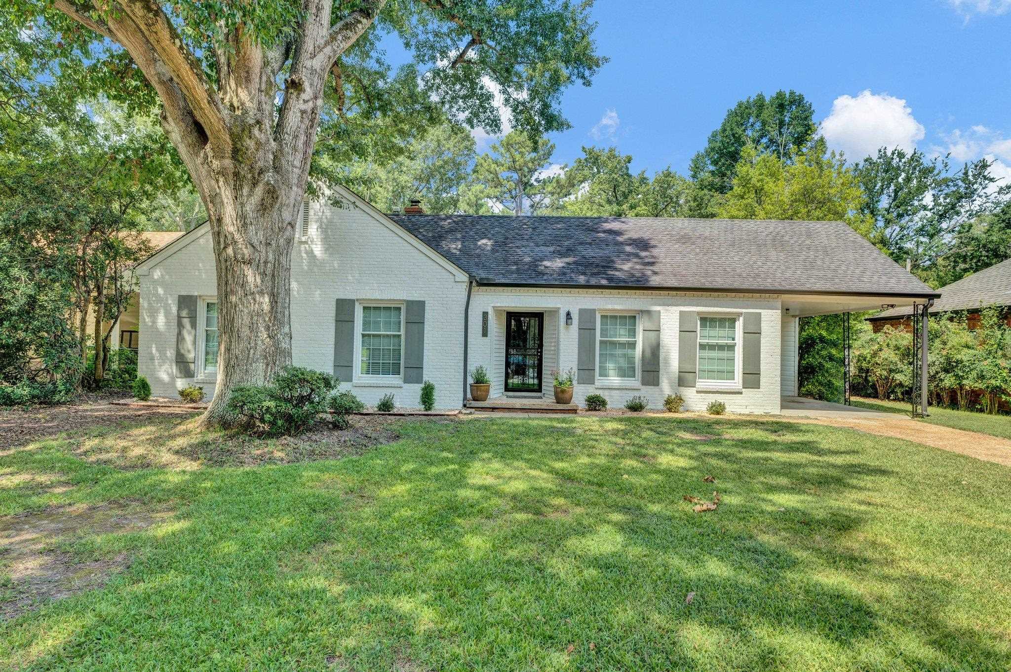 Ranch-style home featuring a carport and a front lawn