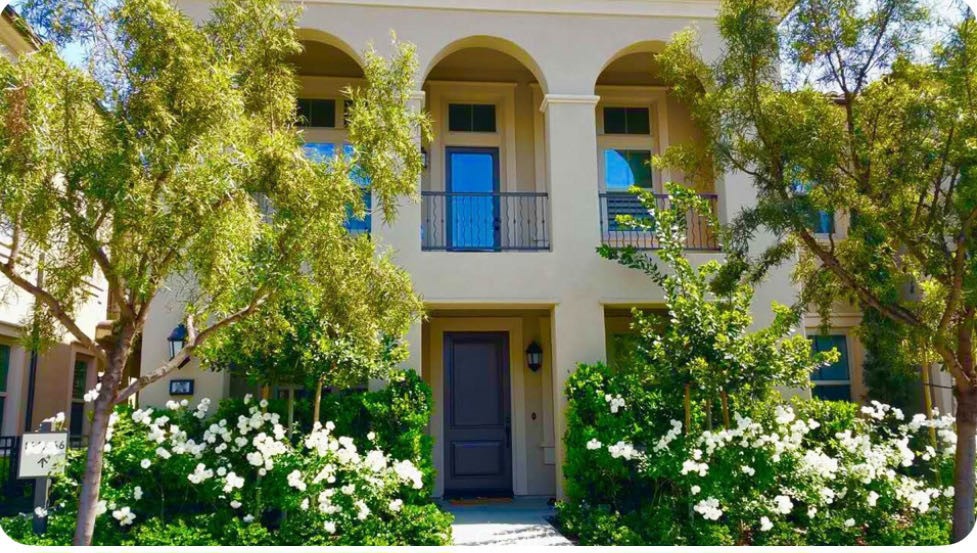 front view of a house with a lot of flower plants