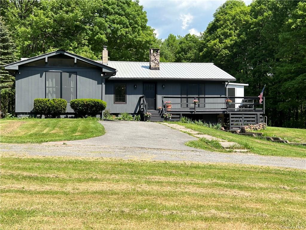 View of front of home featuring a front yard and a deck