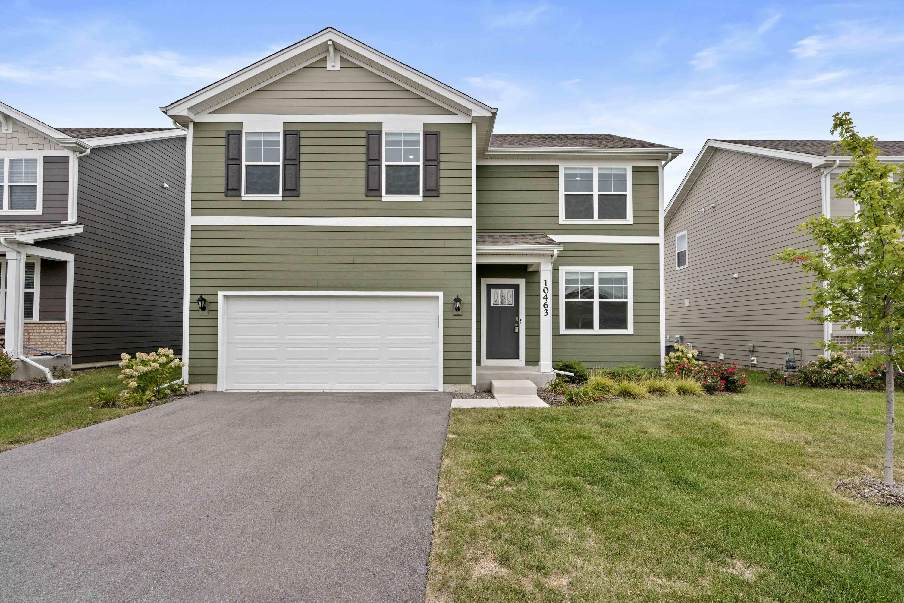 a front view of a house with a yard and garage