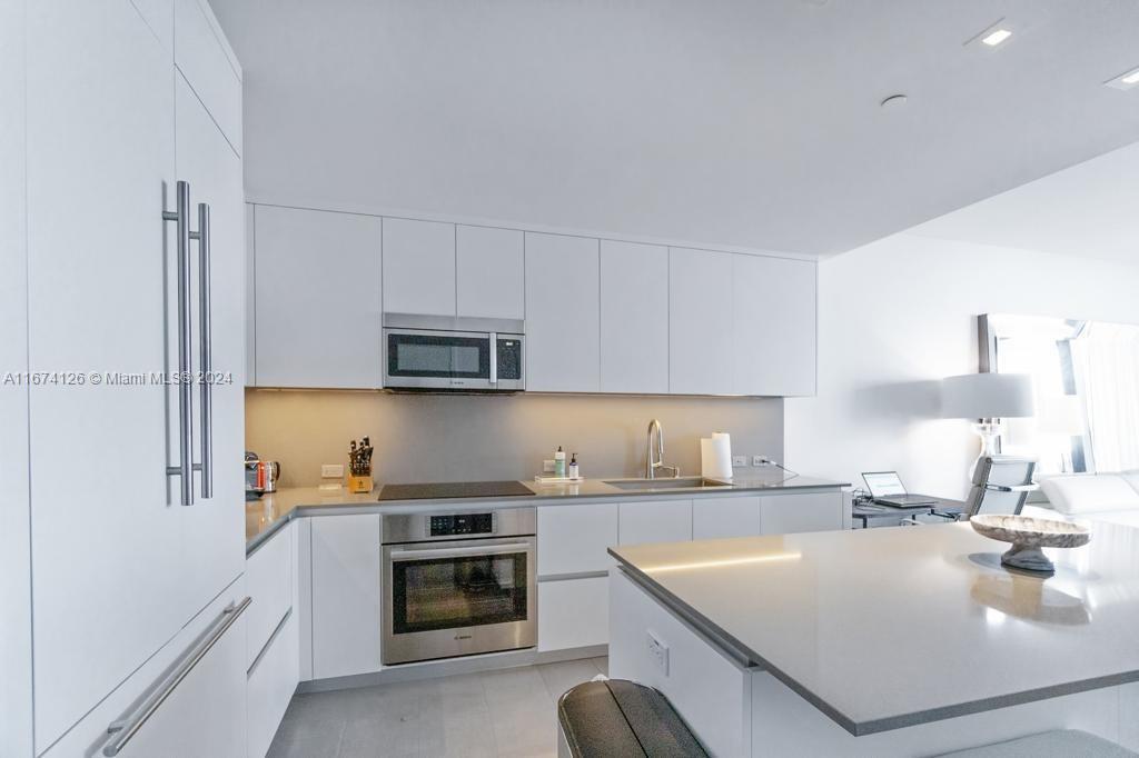 a kitchen with a sink a stove and cabinets