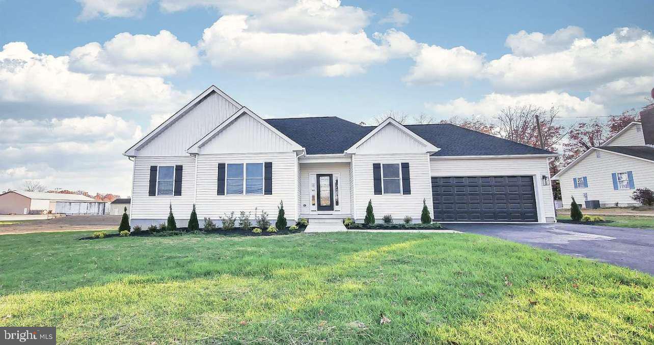 a front view of a house with a garden and yard