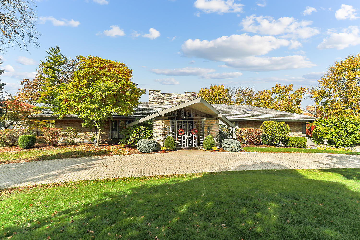 a view of a house with a big yard and large trees