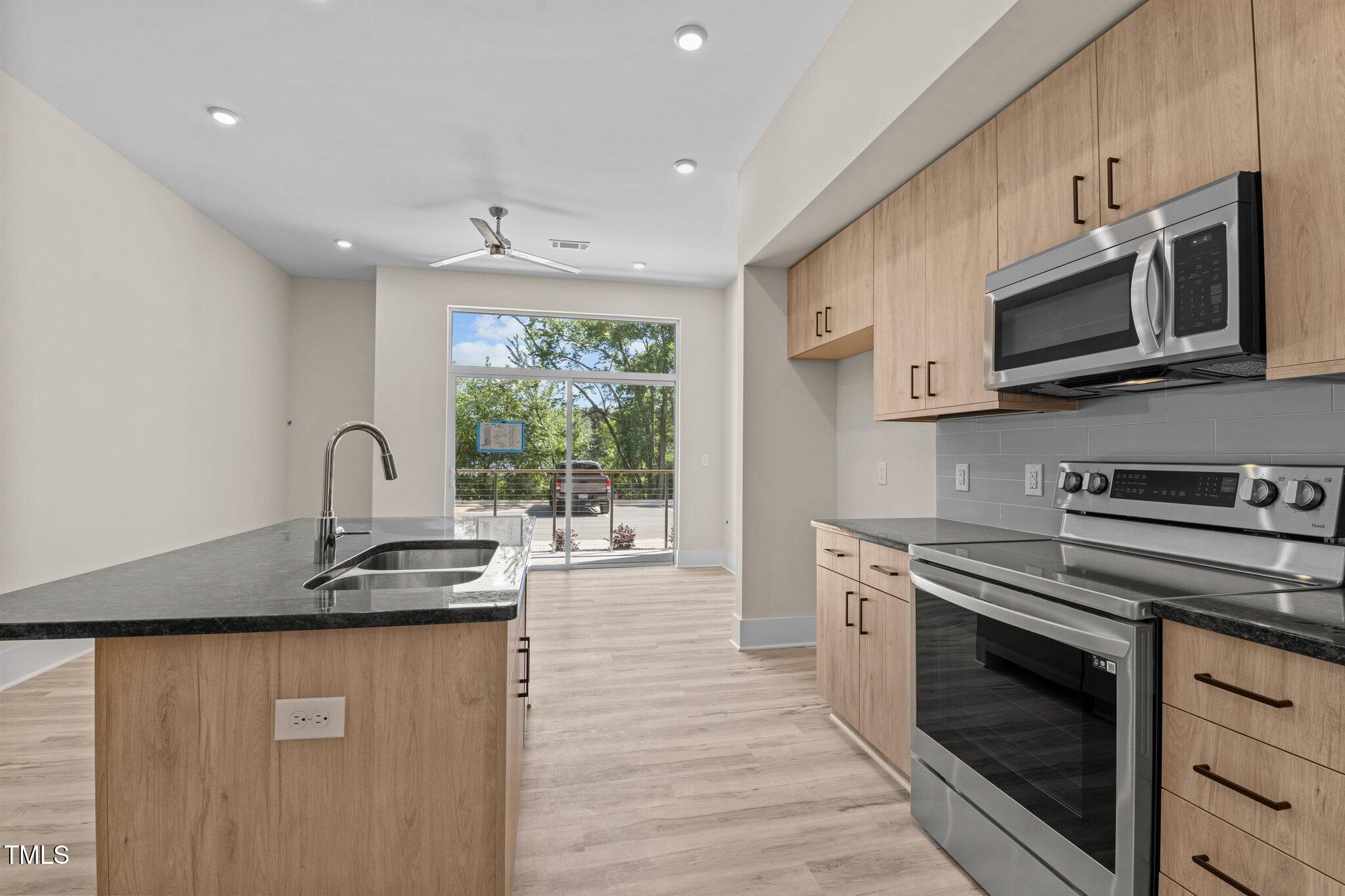 a kitchen with stainless steel appliances granite countertop a stove sink and microwave