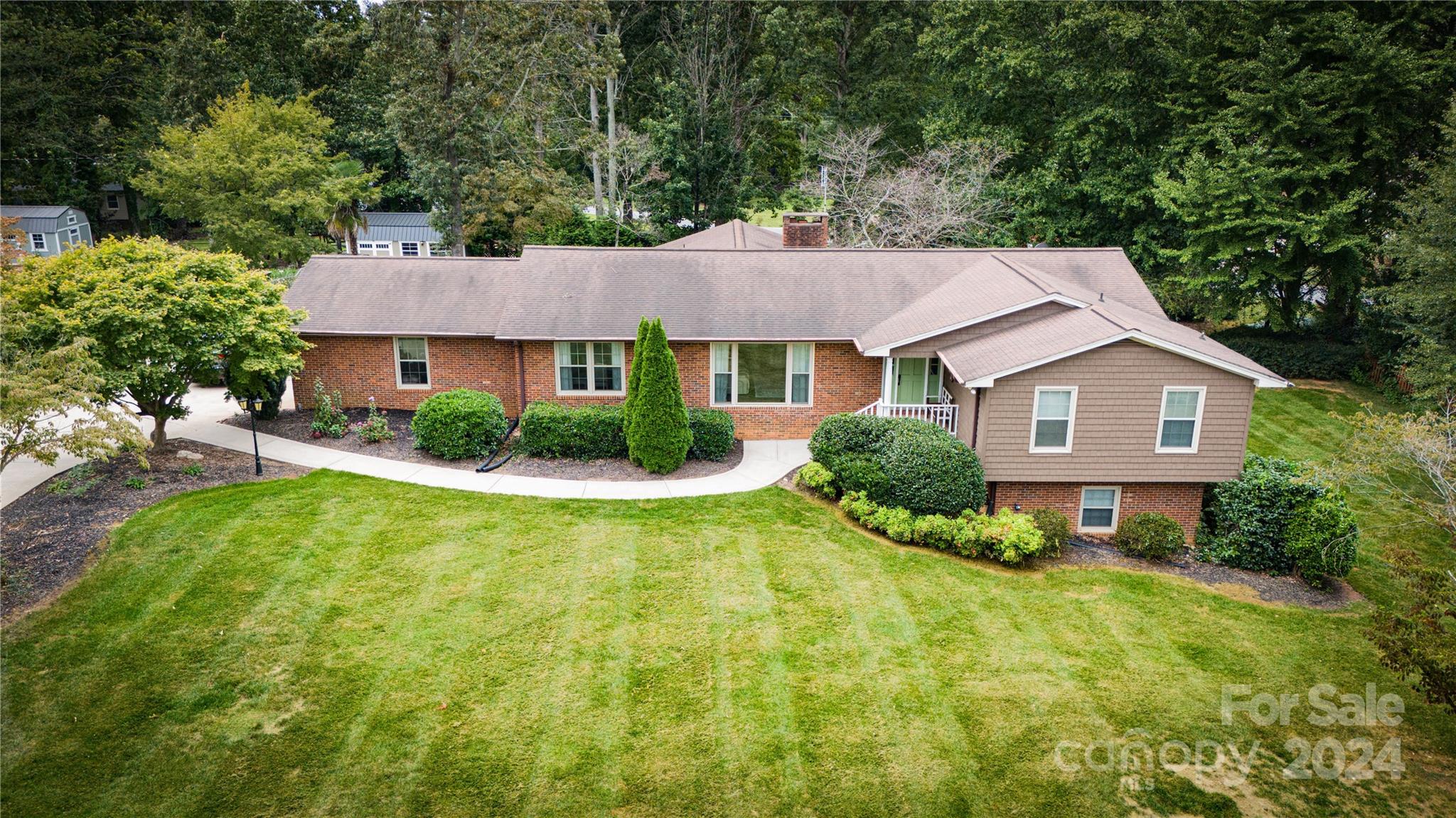 a front view of a house with a yard and trees