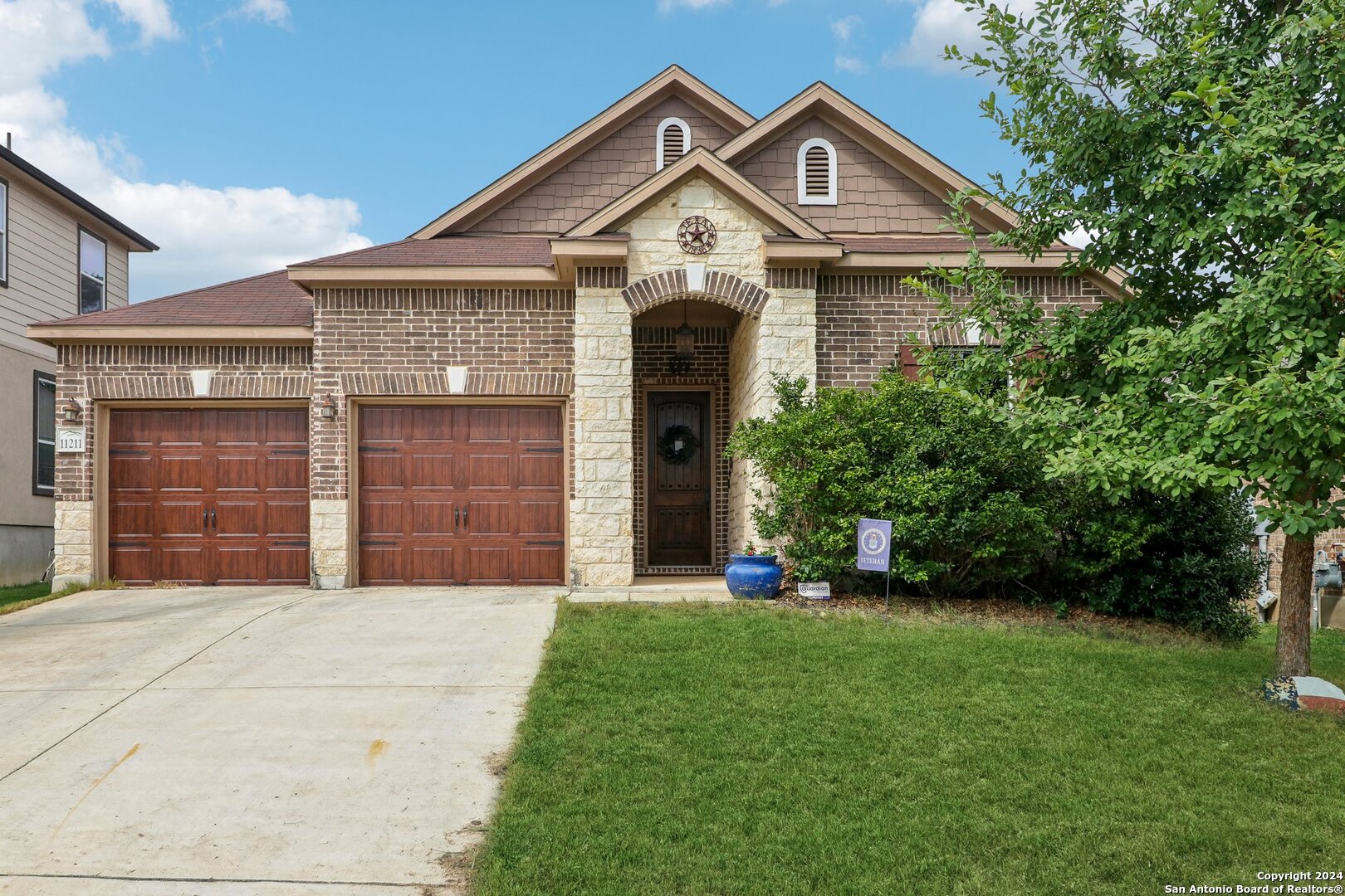 a front view of a house with a garden and yard