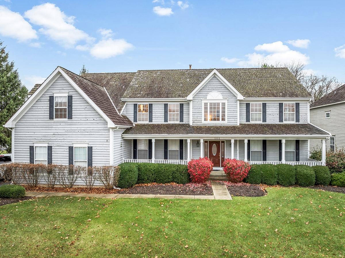 a front view of a house with a yard and potted plants