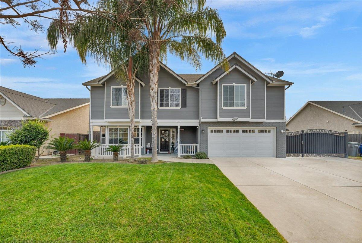 a front view of a house with a yard and palm trees