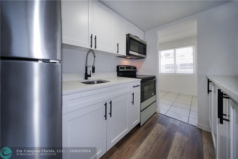 a kitchen with a sink appliances and cabinets