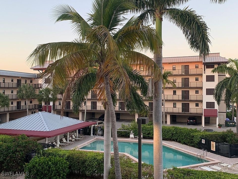 a view of a building with a yard and palm trees