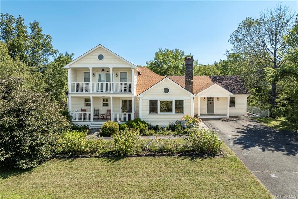 Neoclassical / greek revival house with a front lawn and covered porch