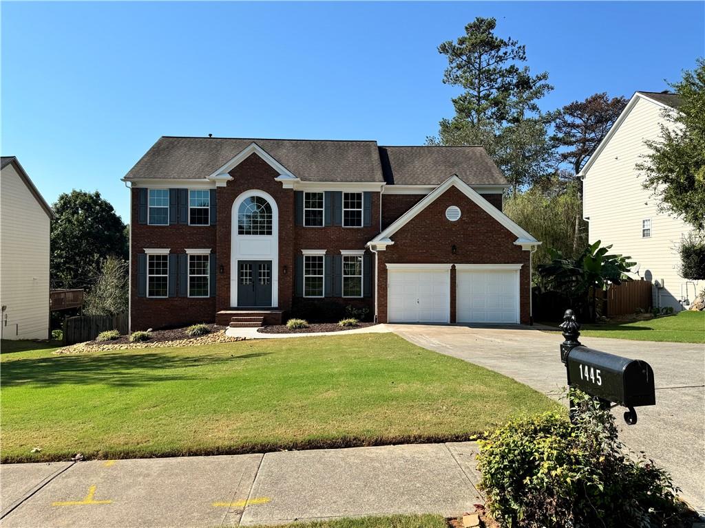 a front view of a house with a yard and garage