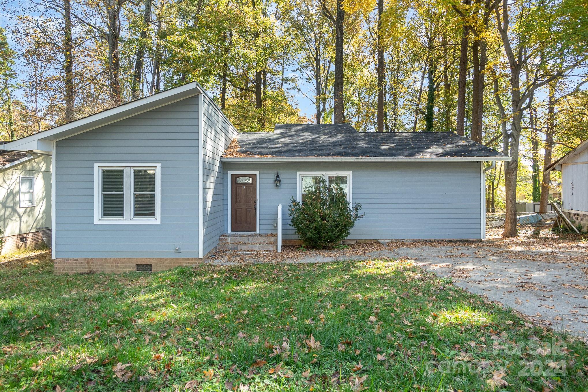 a front view of house with yard and trees around