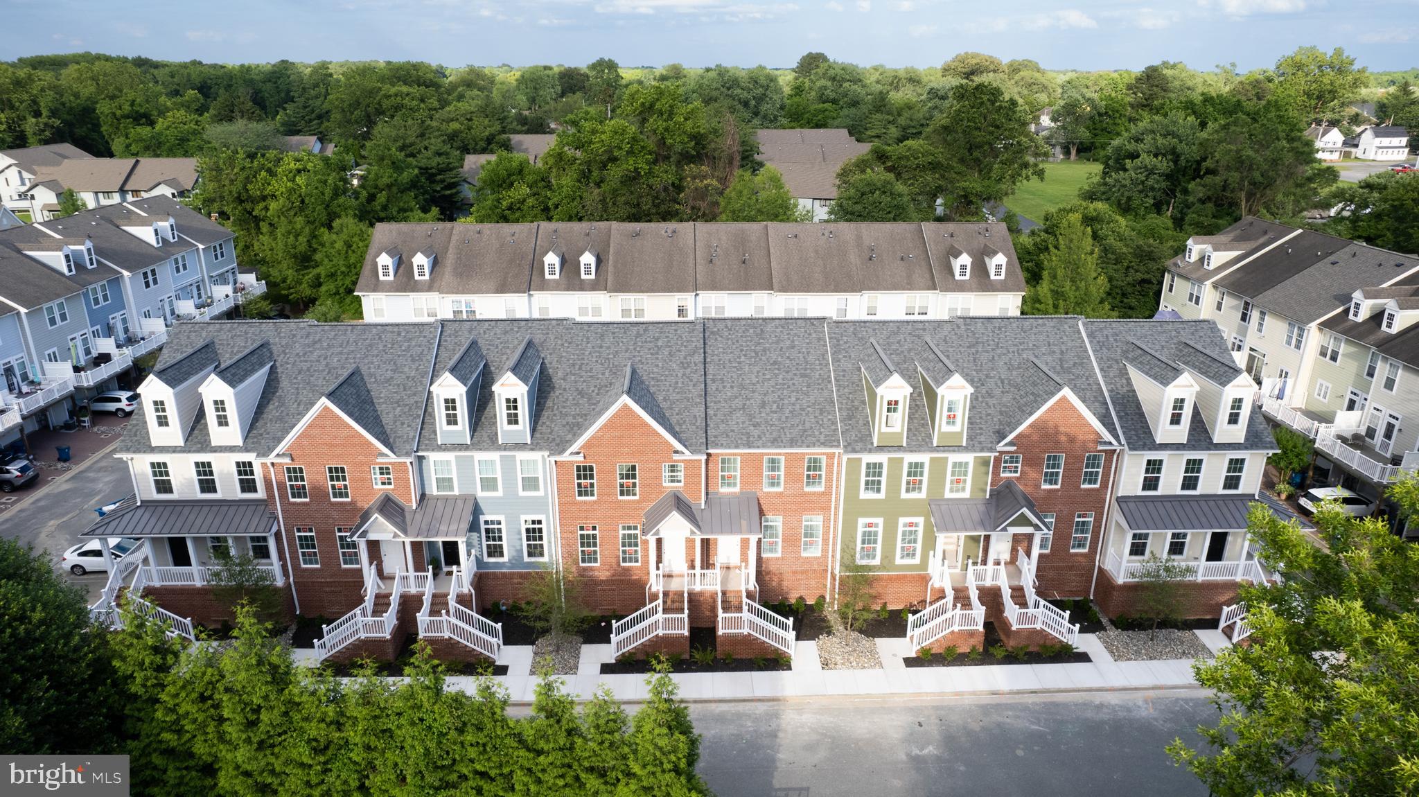 an aerial view of a residential apartment building with a yard and parking spaces