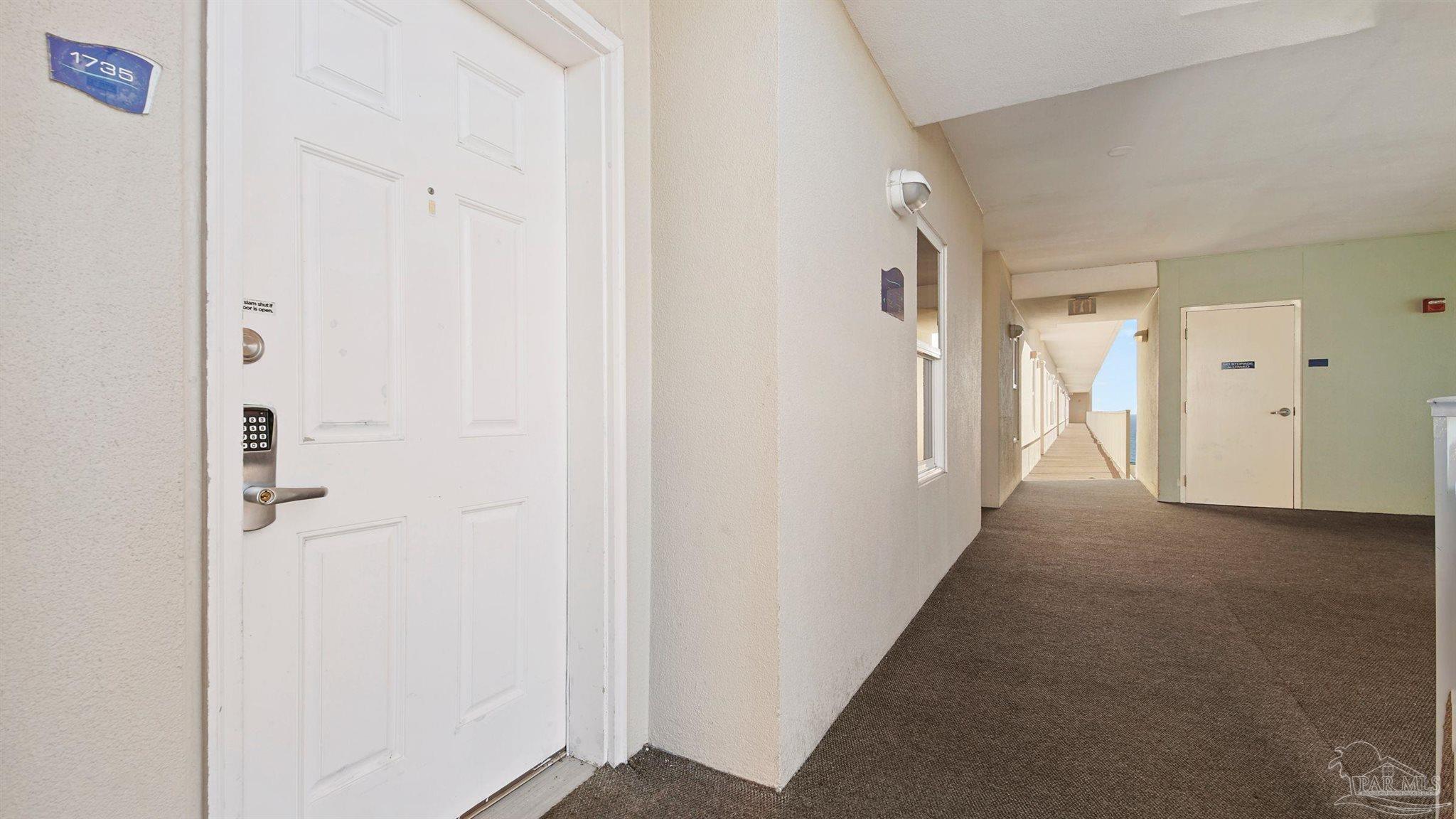 a view of a hallway with closet and door