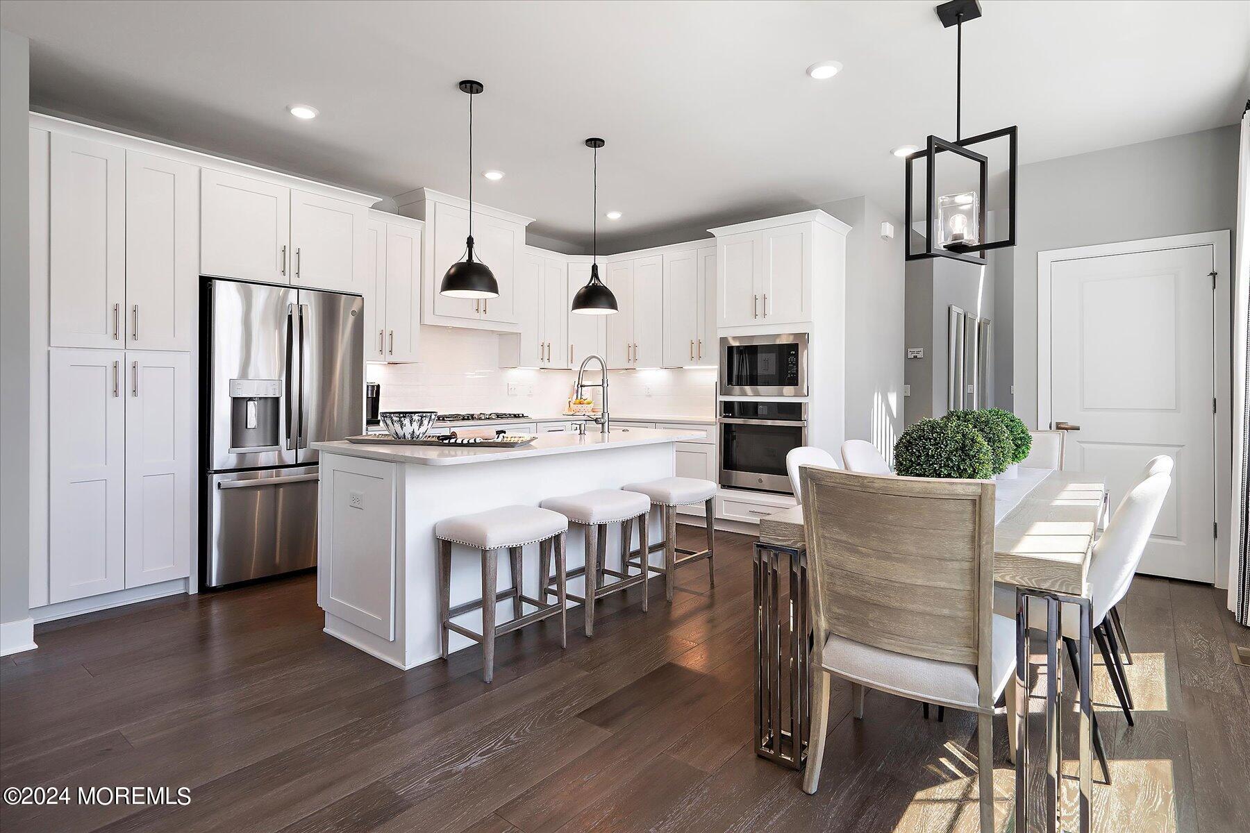 a kitchen with kitchen island white cabinets and stainless steel appliances