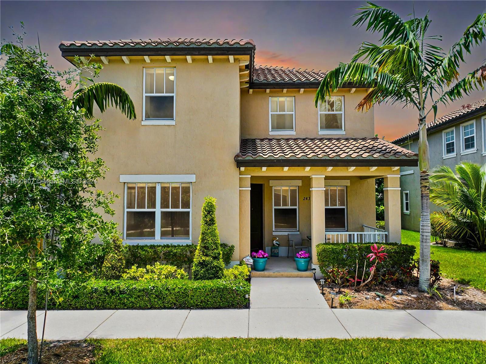 a front view of a house with plants