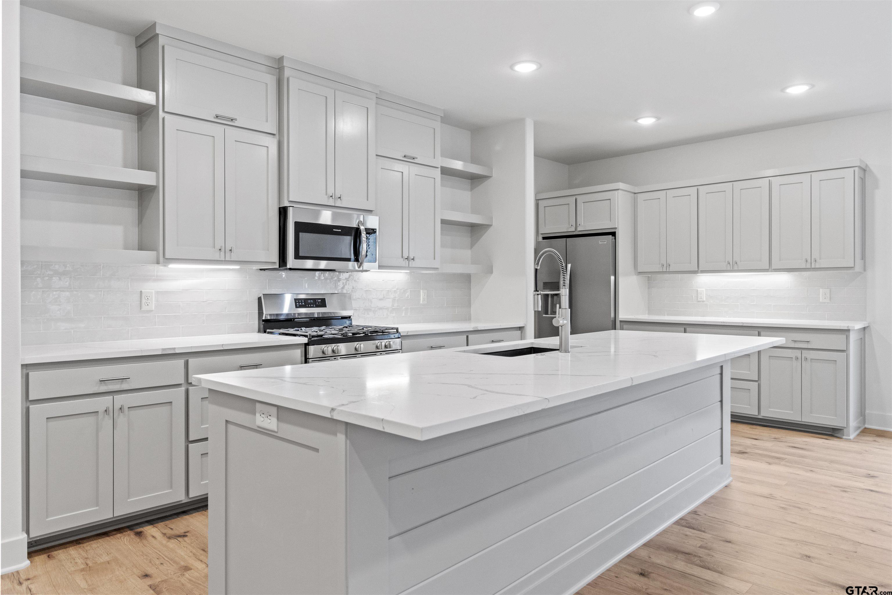 a kitchen with a sink stove and refrigerator