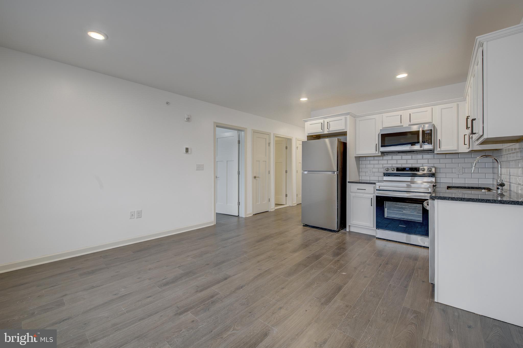 a kitchen with stainless steel appliances a refrigerator and a stove top oven