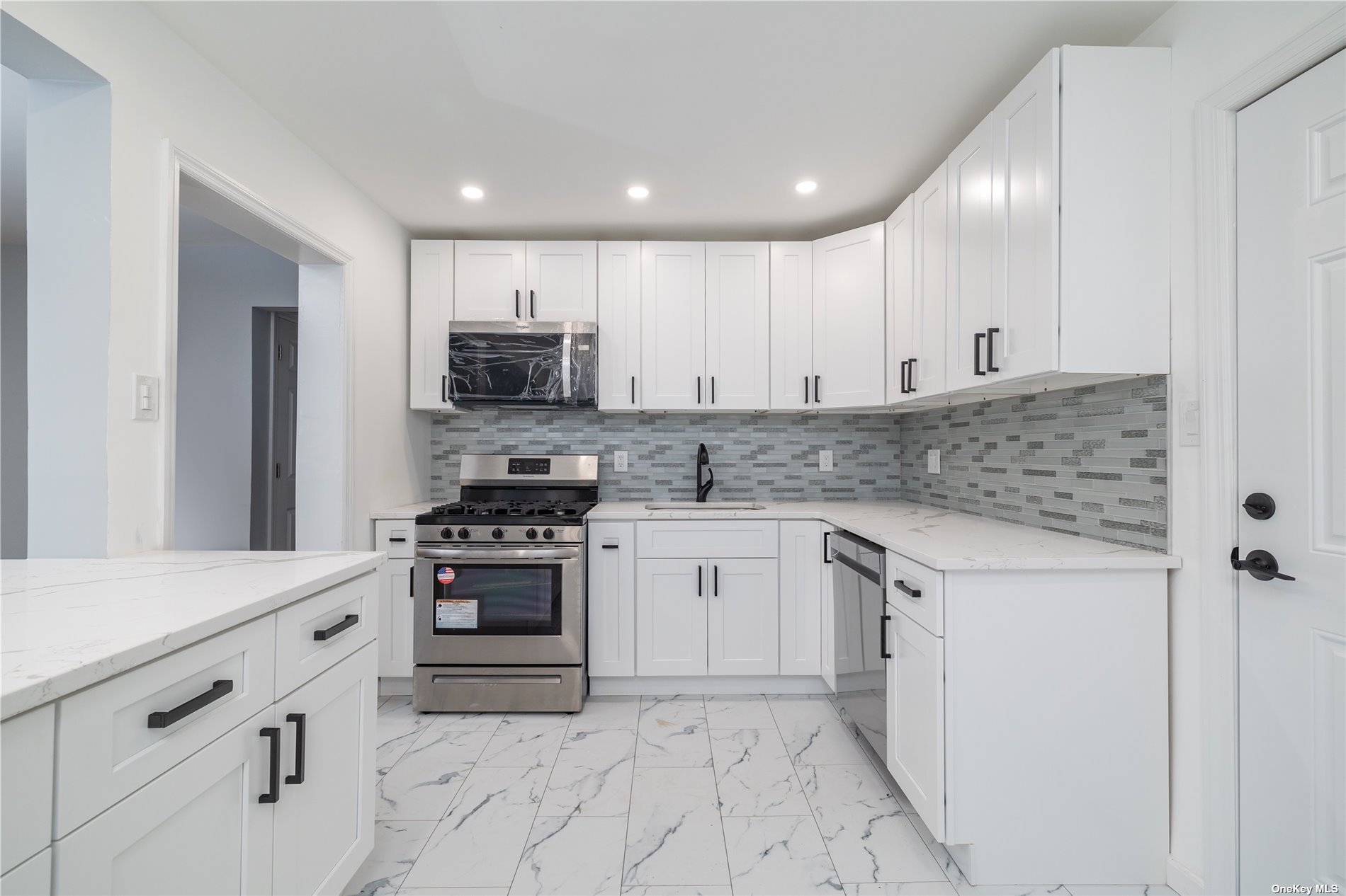 a kitchen with granite countertop white cabinets and stainless steel appliances