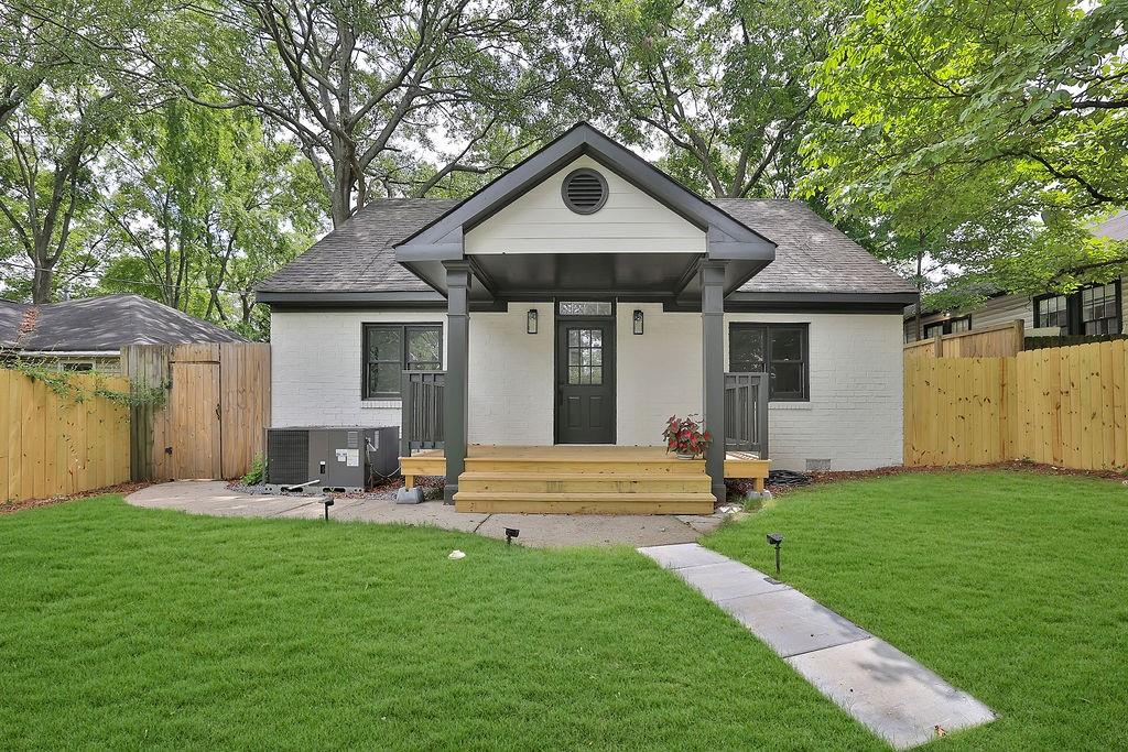 a front view of a house with a yard and trees