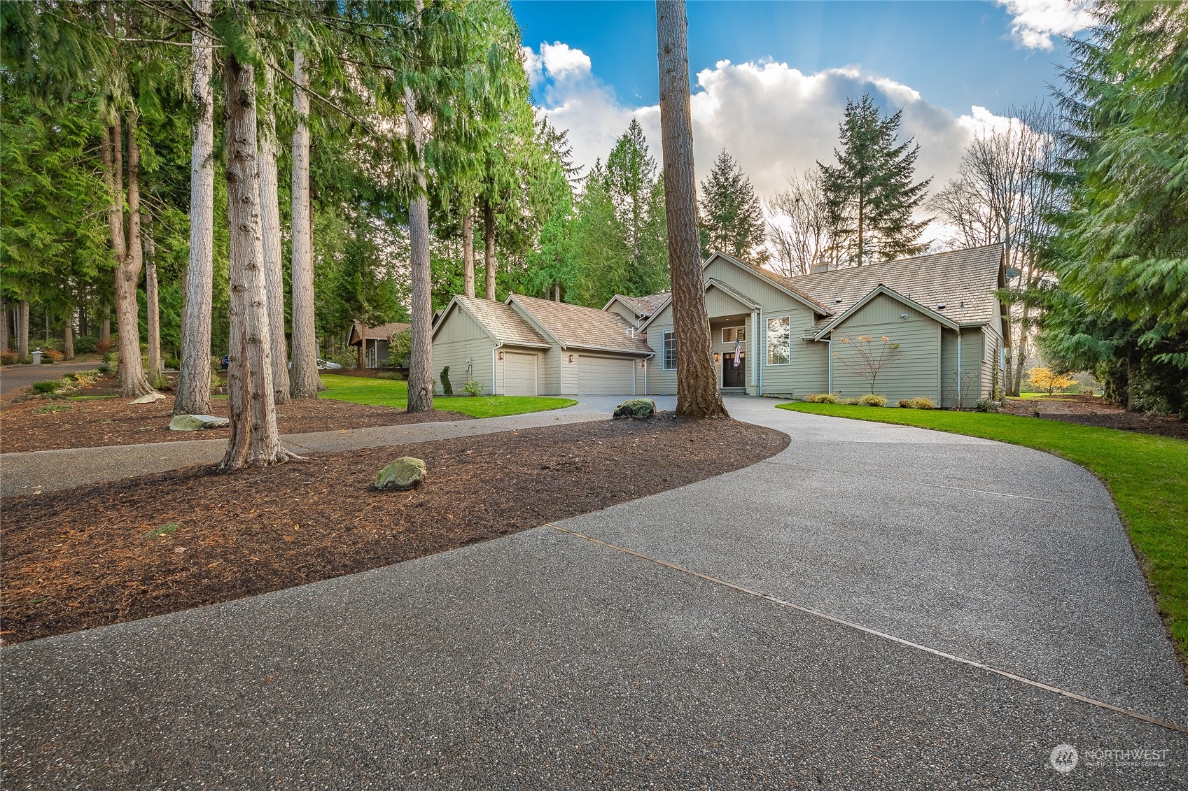 a view of a house with a yard and large trees