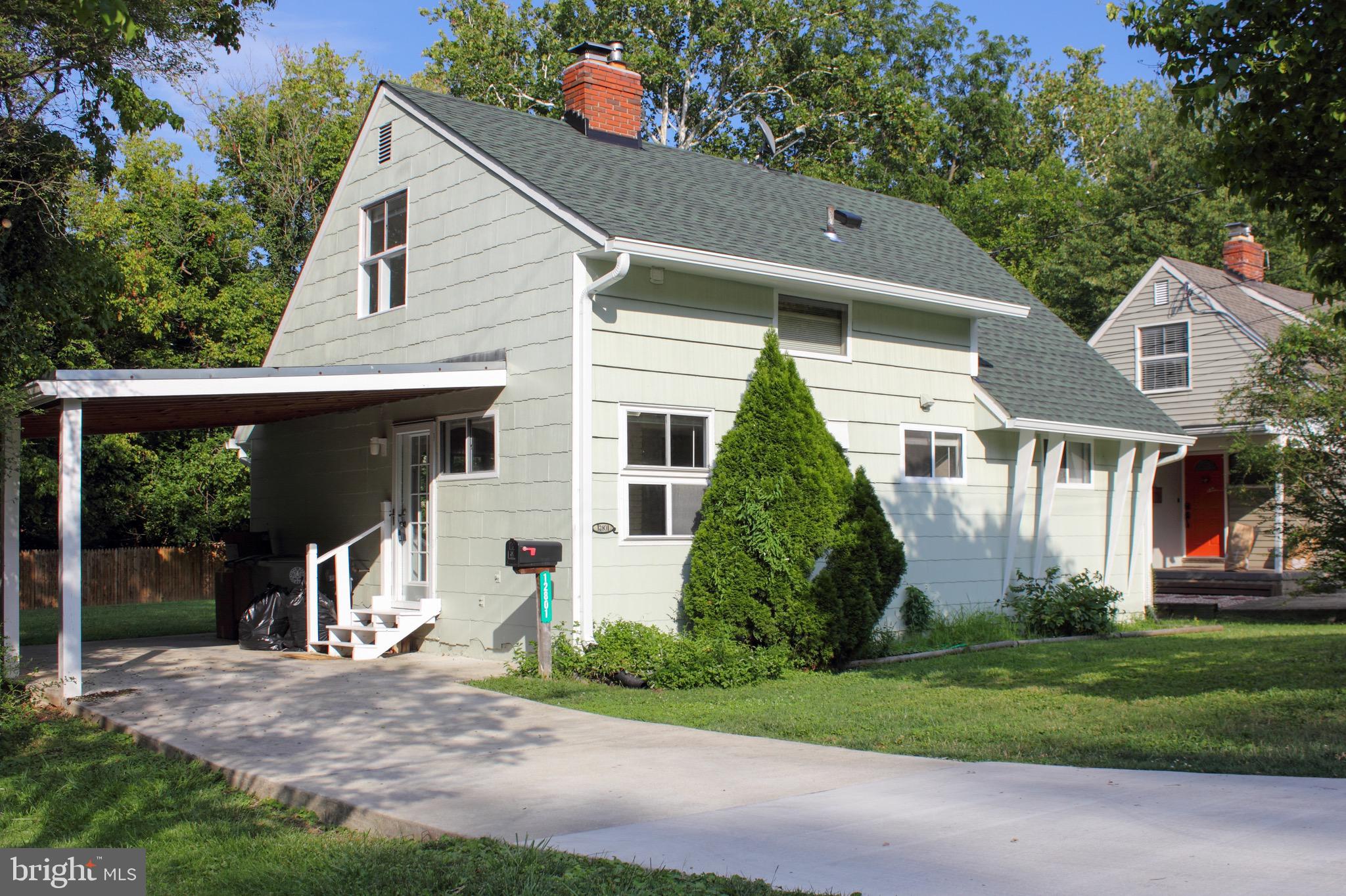 a front view of a house with a yard and potted plants