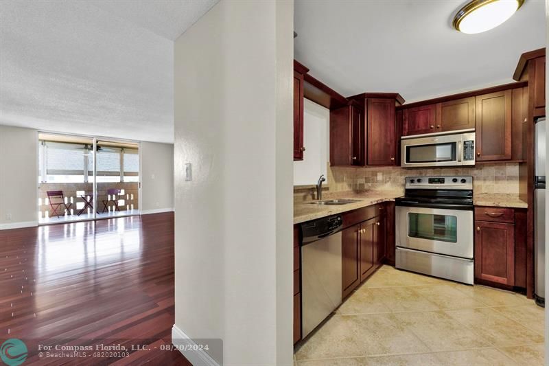 a kitchen with kitchen island granite countertop a stove top oven a sink with granite countertops and cabinets