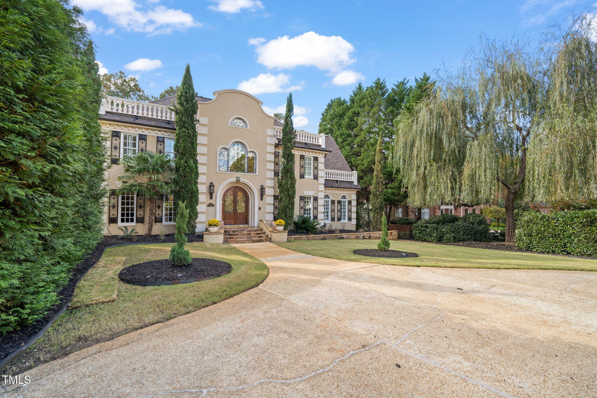 a front view of a house with a yard and trees