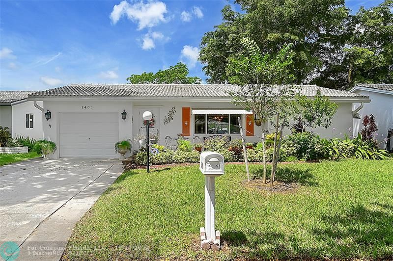 a front view of a house with yard and green space