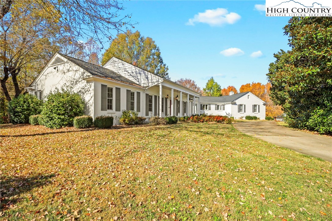 a front view of a house with a yard and potted plants