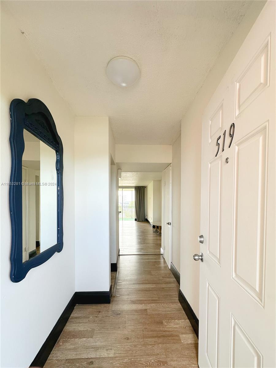 a view of a hallway with wooden floor and staircase