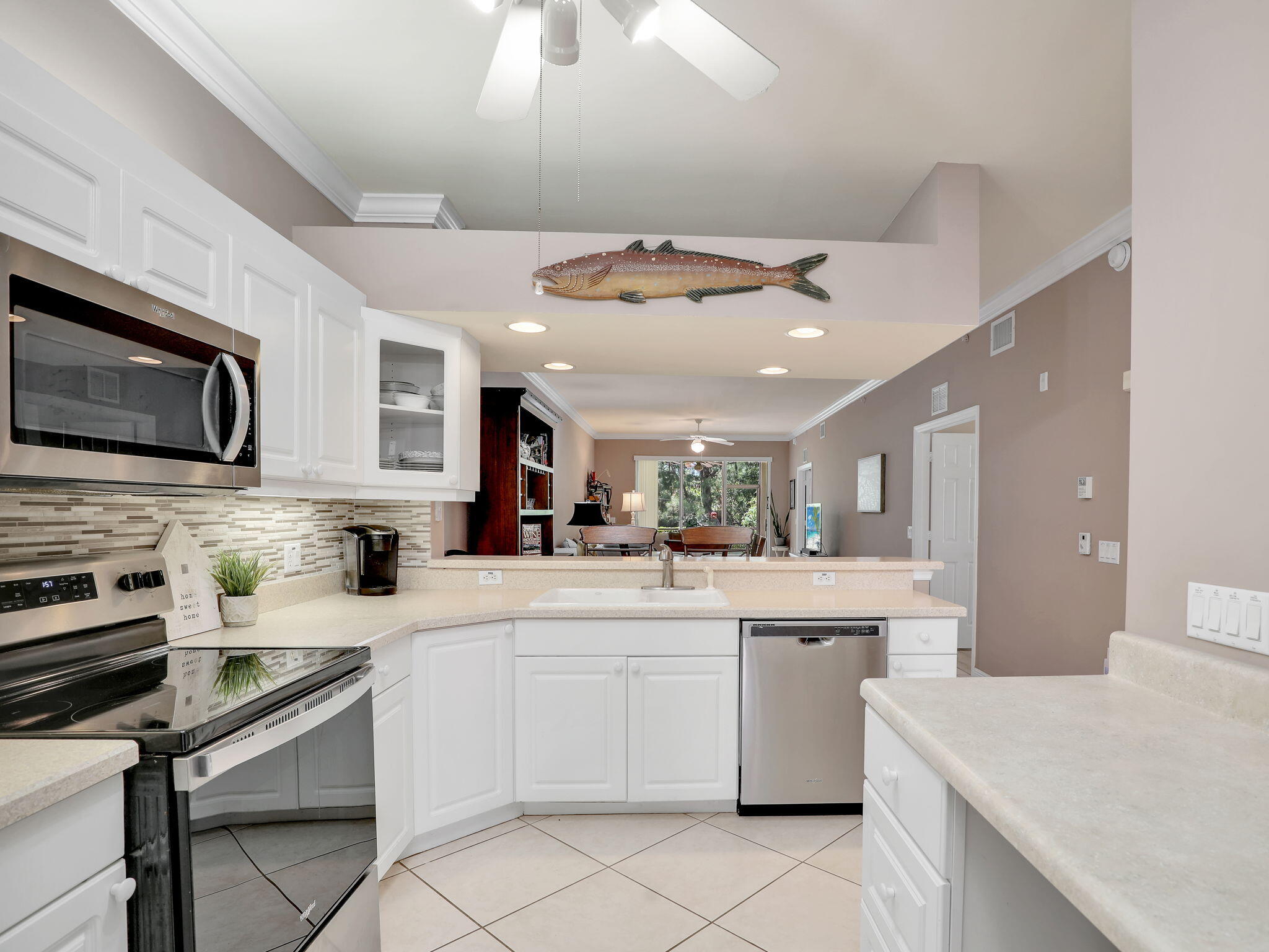 a kitchen with a sink stainless steel appliances and white cabinets