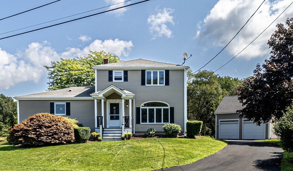 a front view of a house with a yard and potted plants