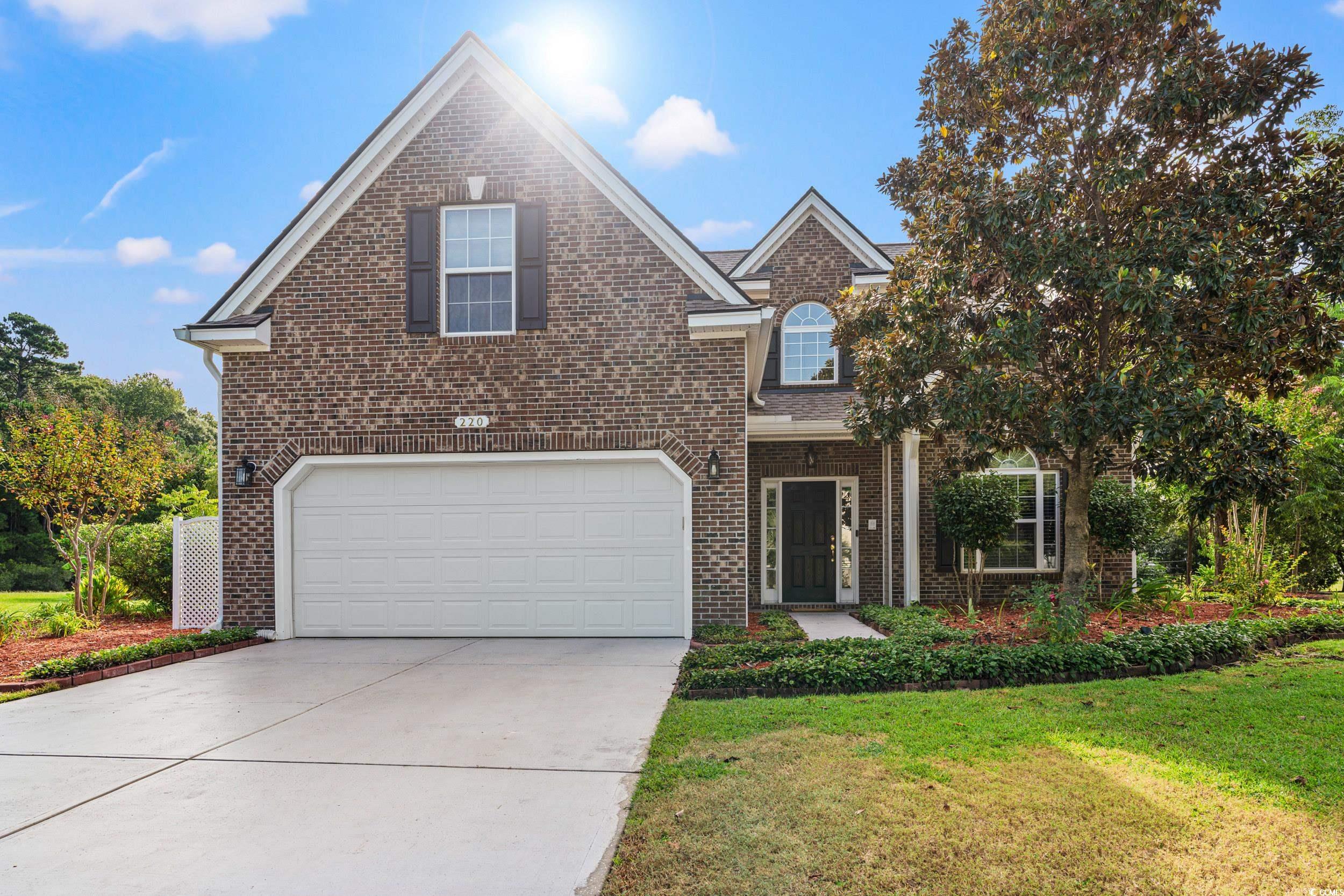 View of property featuring a garage and a front la