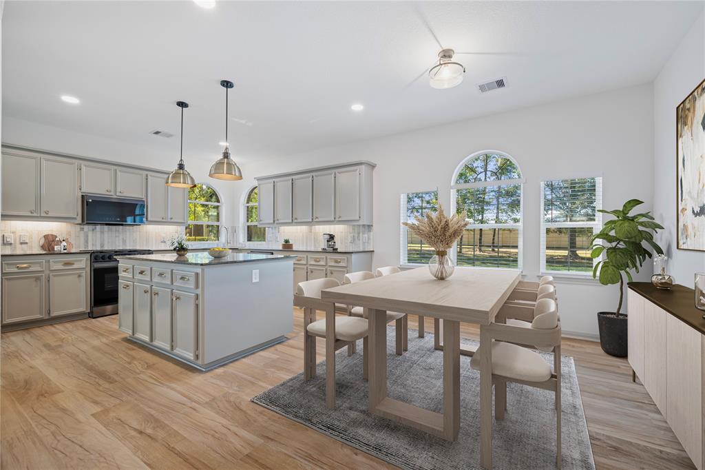 a kitchen with a table chairs microwave and cabinets