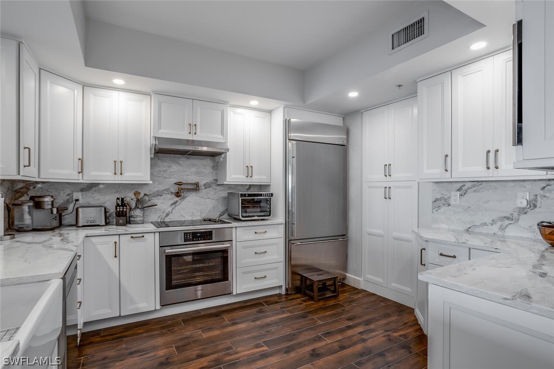 a kitchen with stainless steel appliances a stove a sink and a refrigerator