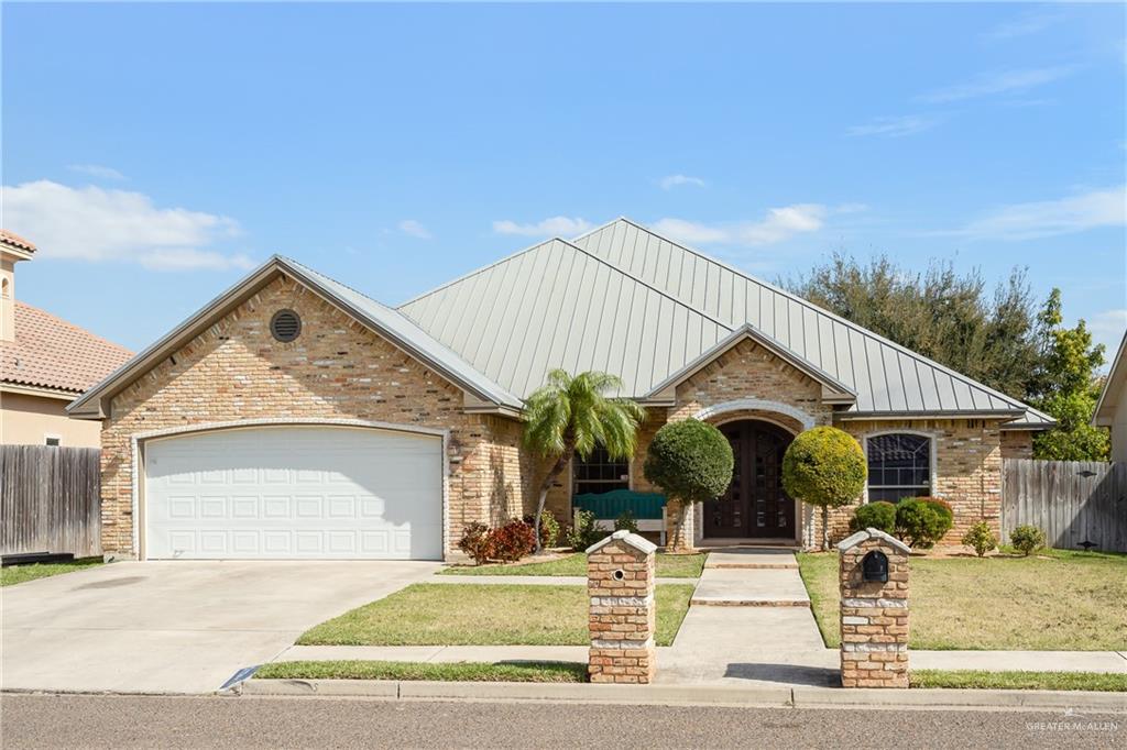 View of front of house with a garage and a front lawn