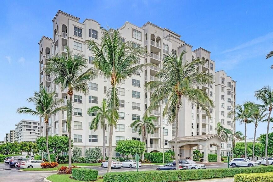 a front view of multi story residential apartment building with yard and sign board