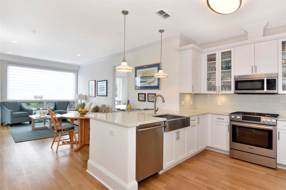 a open kitchen with stainless steel appliances granite countertop a stove and a wooden floors