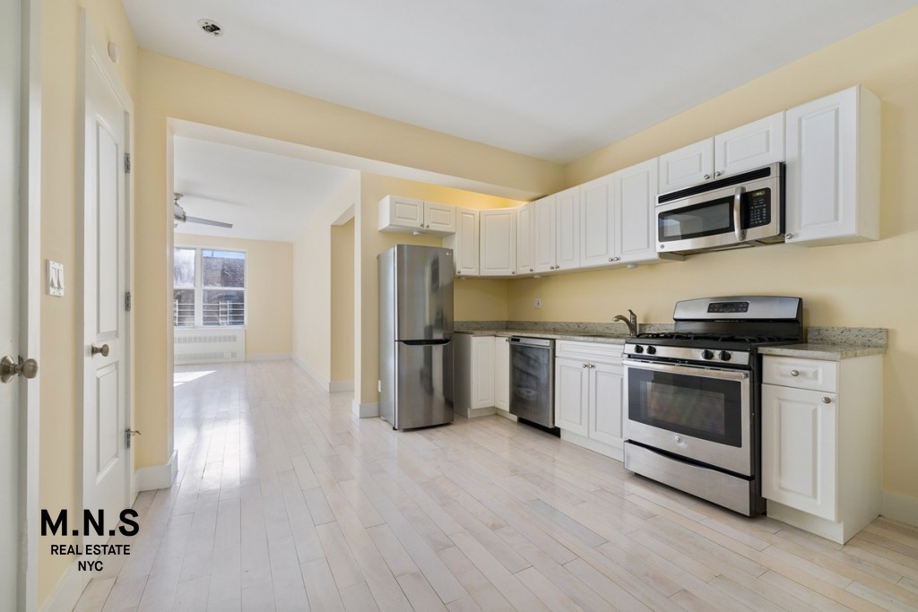 a kitchen with stainless steel appliances white cabinets and a refrigerator